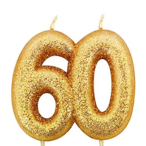 Puede incluir: Velas de cumpleaños de número 60 con purpurina dorada. Las velas están en dos pinchos separados.