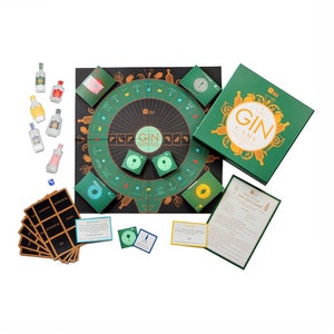 Op de afbeelding: Een groen en gouden bordspel genaamd "The Gin Game: A Masterclass in Gin Cocktails". Het spel bevat een cirkelvormig bord met een zwart midden en een groene buitenring, een set kaarten en een set kleine groene en gouden fiches. Het spel is ontworpen voor volwassenen en is perfect voor ginliefhebbers.