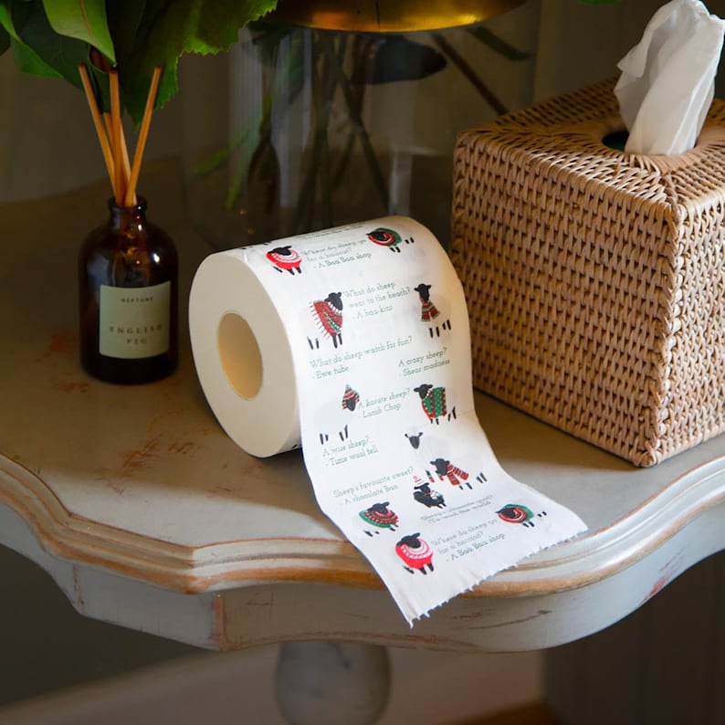 K&ouml;nnte beinhalten: Eine Rolle Toilettenpapier mit einem schwarzen Schaf-Design und einem lustigen Schaf-Reim. Der Text lautet: "Was tragen Schafe am Strand? Ein baa kin! Was waschen Schafe zum Spa&szlig;? Ewe tube! Ein Knotenschaf? Lamb Chop! Tie wool tell? Time was wool tell! Die Lieblingss&uuml;&szlig;igkeit von Schafen? Ein Schokoladen-baa! Was sagen Schafe zu einem baa baa Schaf? Ein baa baa Schaf!"