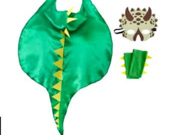 Könnte beinhalten: Ein grünes Satin-Dinosaurier-Kostüm-Set, bestehend aus einem Umhang mit gelben Dreiecksakzenten, einer passenden Maske mit braunen Hörnern und Handgelenkmanschetten mit gelben Stacheln. Kinderkostüm.
