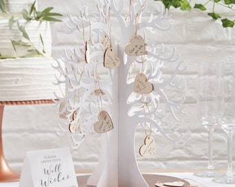 May include: White wooden tree with hanging heart-shaped tags for guests to sign their well wishes. The sign reads "Please leave your well wishes. Sign a heart then add it to the tree!"
