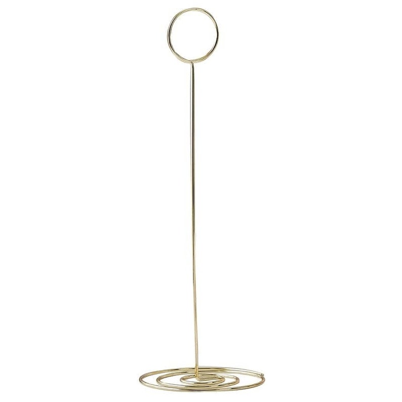 May include: A gold metal picture frame stand with a round top and a spiral base.