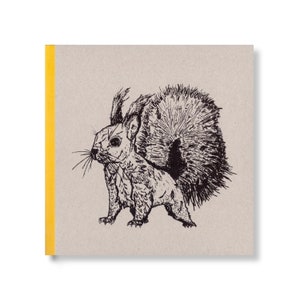 Könnte beinhalten: Ein quadratisches Notizbuch mit beigem Einband und gelbem Rücken. Das Cover zeigt eine detaillierte Schwarz-Weiß-Illustration eines Eichhörnchens. Das Eichhörnchen ist im Seitenprofil dargestellt, mit seinem buschigen Schwanz.