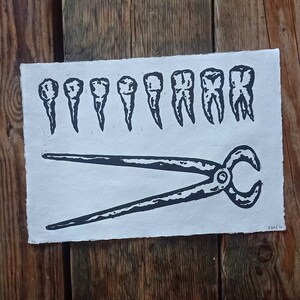 May include: A black and white linocut print of a row of teeth and a pair of pliers. The print is on a white background.