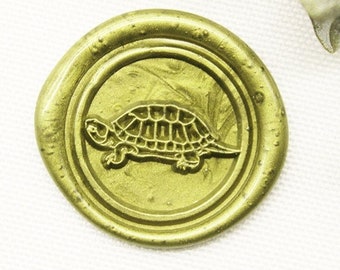 May include: A gold wax seal with a detailed image of a turtle.