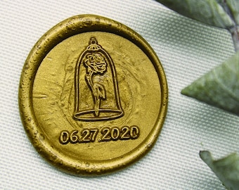 Op de afbeelding: Gouden waszegel met een reliëfbeeld van een roos in een glazen koepel. De datum 06.27.2020 is onder het beeld gegraveerd.