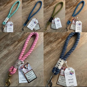 May include: Five different colors of cotton rope dog leashes with a leather grab handle. The leashes are 18 inches long and are handmade. The colors are teal, blue, green, pink, and denim.