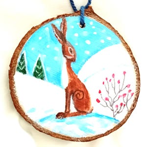 hand painted wood slice with brown hare  berries and fir trees in snow