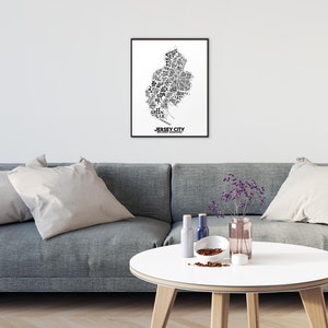 May include: Black and white typography art print of Jersey City, New Jersey. The print features the names of neighborhoods and landmarks within the city's outline.