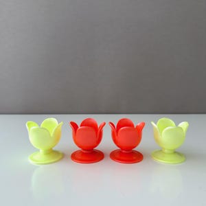 Könnte beinhalten: Vier Eierbecher in Tulpenform. Zwei sind gelb und zwei sind rot.