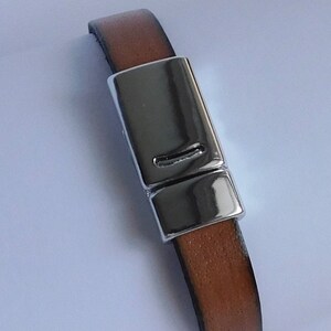 May include: A brown leather bracelet with a silver magnetic clasp.