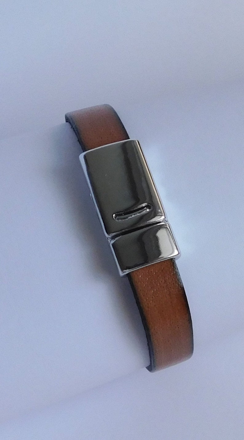 May include: A brown leather bracelet with a silver magnetic clasp.