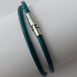 May include: A teal blue leather bracelet with a silver magnetic clasp.