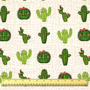 May include: Fabric with a repeating pattern of cartoon cacti in various shapes and sizes. The cacti are green with smiling faces and some have red bows or flowers. The background is white with pink polka dots and vertical lines.