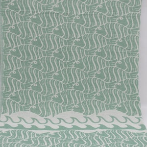 May include: A green fabric with a white fish pattern and a white wave border.