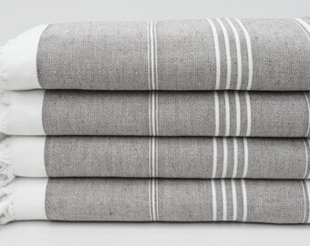 May include: A stack of four gray and white striped towels with fringed edges.