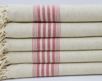 May include: A stack of five cream-colored kitchen towels with red stripes. The towels have fringe on the ends.