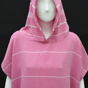 May include: Pink hooded towel with white stripes. The towel is made of a soft, absorbent material and is perfect for drying off after a swim or shower.