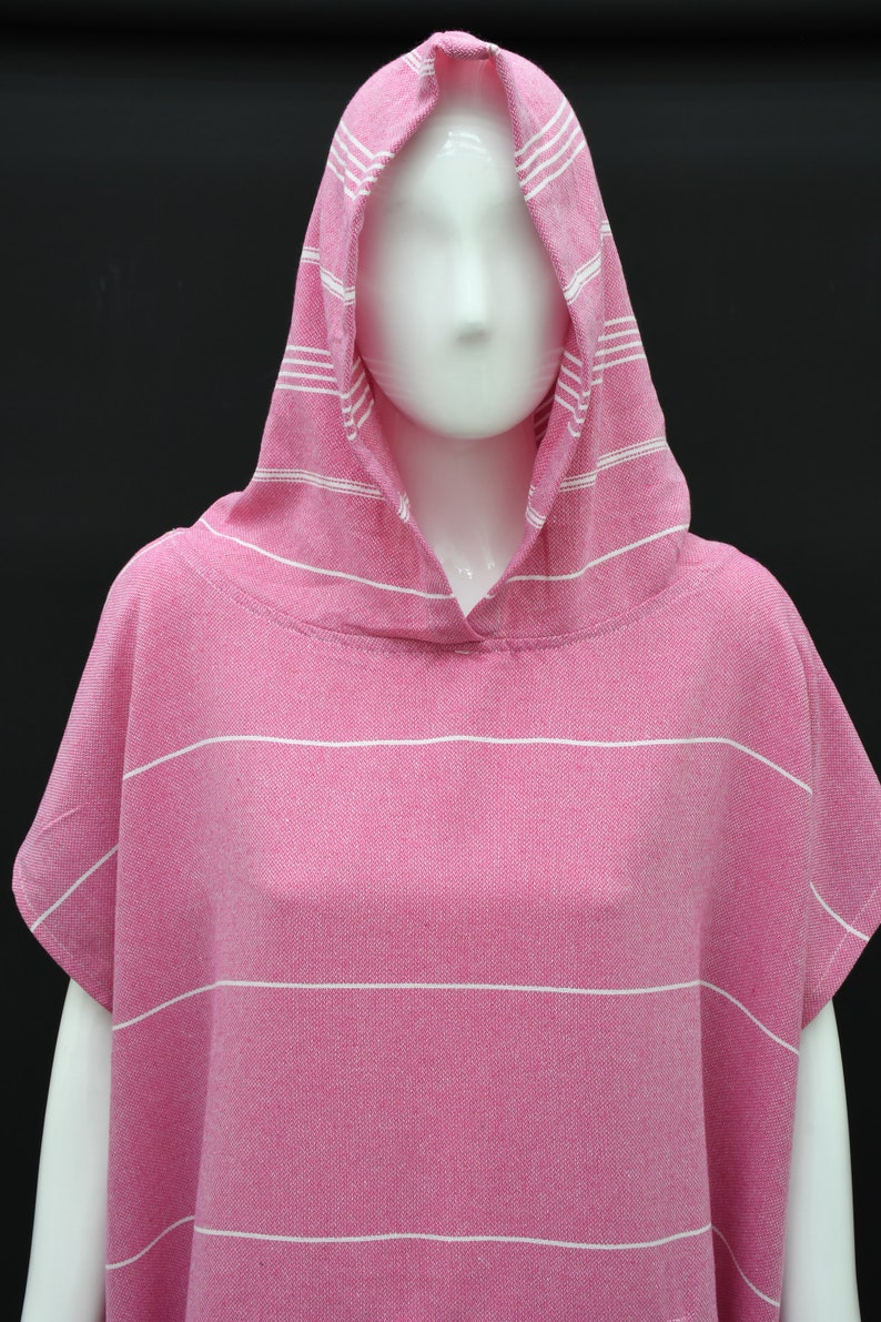 May include: Pink hooded towel with white stripes. The towel is made of a soft, absorbent material and is perfect for drying off after a swim or shower.