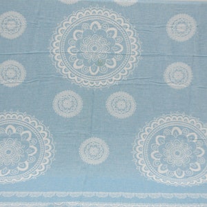 May include: A light blue fabric with a white mandala pattern. The fabric has a soft, textured feel.