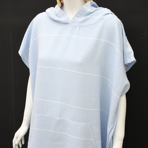 May include: A light blue hooded towel with white stripes. The towel has a pocket on the front.