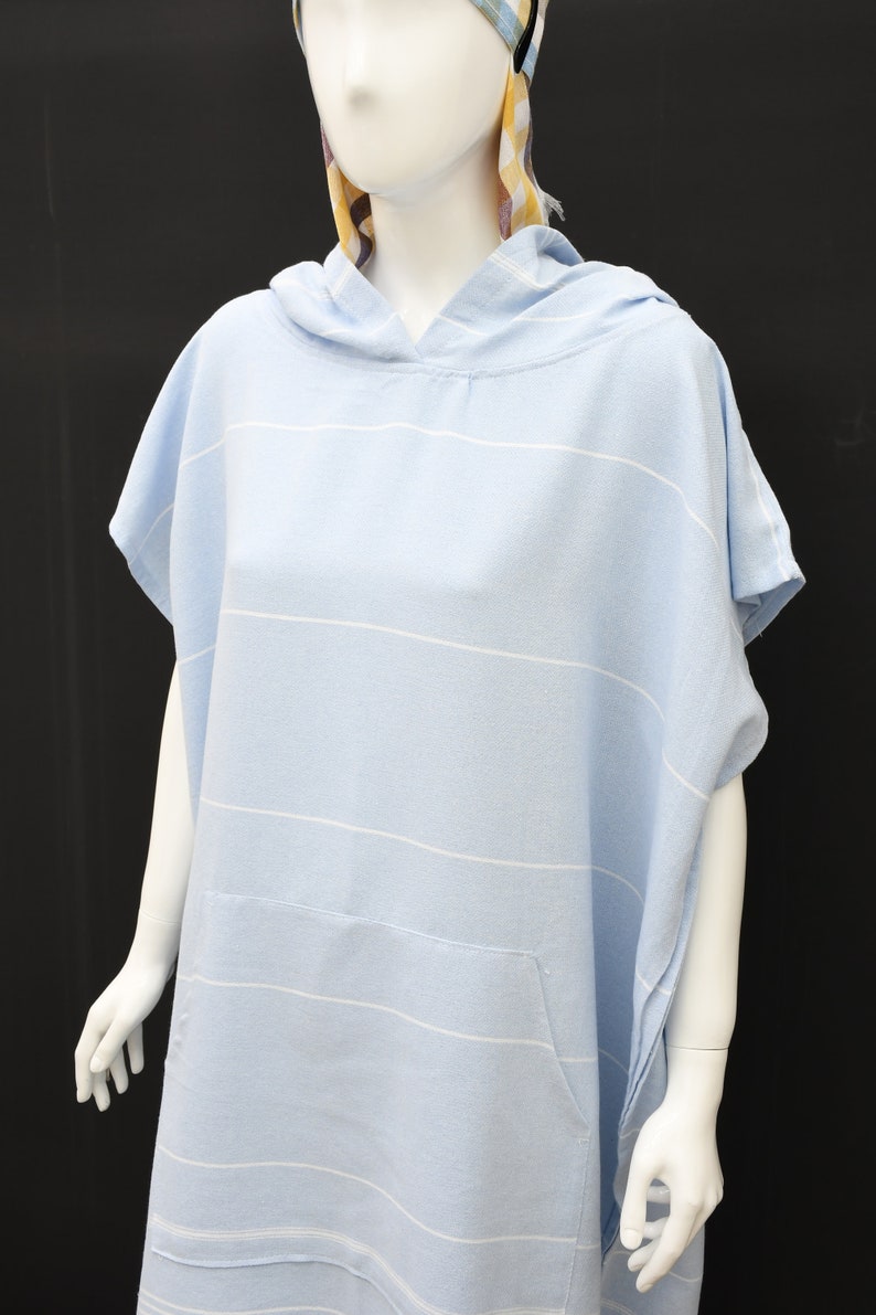 May include: A light blue hooded towel with white stripes. The towel has a pocket on the front.