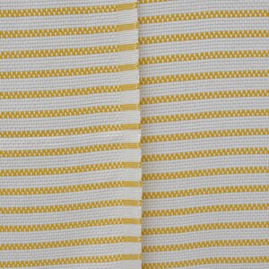 May include: White fabric with yellow stripes. The fabric has a woven texture.