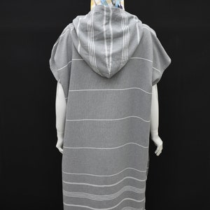 May include: Gray hooded towel with white stripes. The towel has a fringe around the bottom edge.