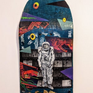 Standing In a New World - mixed media collage on a broken skateboard