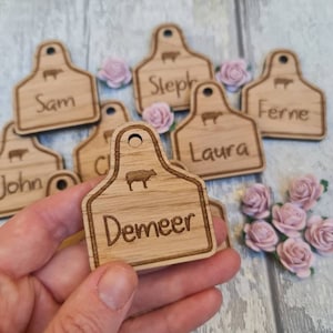 Wooden wedding name place settings in the shape of a cow ear tag. Farmers wedding. Wedding favour