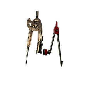 May include: Two metal drafting compasses. One is gold-colored with a curved handle and a sharp point. The other has silver legs and a red top and pivot. Both are open and ready for use, set against a white background.
