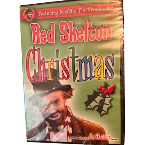 May include: DVD case for "Red Skelton Christmas" featuring Freddie The Freeloader. The cover has a green background with the title in red and colorful letters. A picture of Red Skelton in character is at the bottom, with holly and berries on the right.