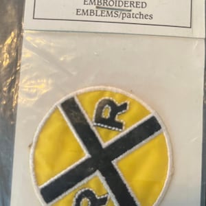 May include: Embroidered iron-on patch featuring a yellow circle with a black cross and the letters "R" on either side. The patch is labeled "TRUE TO LIFE IRON-ON EMBROIDERED EMBLEMS/patches".
