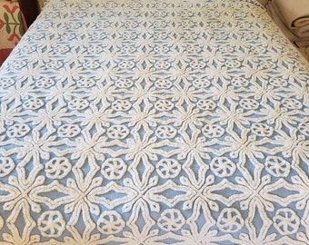 Könnte beinhalten: Eine blaue und weiße gesteppte Bettdecke mit einem Blumenmuster. Die Bettdecke ist aus einem weichen, plüschigen Stoff gefertigt und hat ein erhabenes Design.