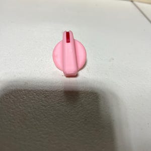 May include: A white ceramic mug with a black handle and the text "But First, Coffee" in a handwritten style. The mug is on a white surface. The mug is approximately 10 cm tall.