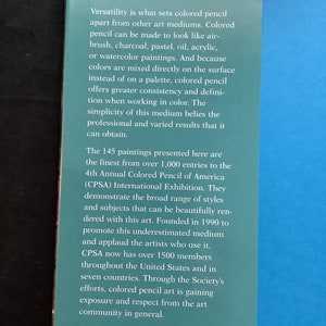 K&ouml;nnte beinhalten: Ein Buchcover mit blauem Hintergrund und dem Titel "Colored Pencil 4" in goldenen Buchstaben. Der Text beschreibt das Buch als eine Sammlung von 145 Gem&auml;lden aus &uuml;ber 1.000 Einsendungen zur 4. Internationalen Ausstellung der Colored Pencil of America (CPSA).