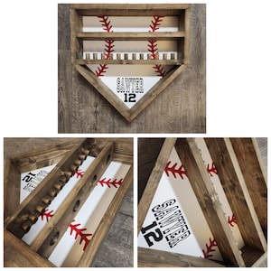 Puede incluir: Un estante de madera para exhibir bates de béisbol con fondo blanco y costuras rojas. El estante tiene dos niveles y tiene forma de diamante de béisbol. El nombre "Sawyer" y el número "12" están impresos en la parte delantera del estante.