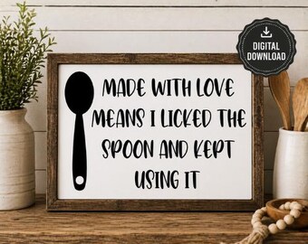 May include: A framed sign with the text "MADE WITH LOVE MEANS I LICKED THE SPOON AND KEPT USING IT" in black lettering. A black spoon graphic is on the left. The sign is in a rustic brown frame, with a digital download icon.