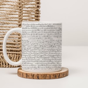 May include: White ceramic mug with a black and white text design. The text is in a cursive font and reads: "She perhaps aborting something from him? No, the tenderness between the pair was evident even at this distance. The lower half of his jaws as he considered what to do. Poppa's business was more important than any other consideration. Before he dashing over to beat his sister's new husband to a bloody pulp, he'd find out exactly what the situation was. April circumstances were long, slow, measured breaths. Leo watched the pair. Rutledge stood and went back to the house, while Mrema..."