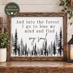 May include: A rectangular wall sign with a dark brown wood frame featuring a white background and black text that reads, And into the forest I go to lose my mind and find my soul. The bottom of the sign displays a black forest tree graphic.