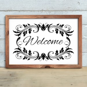 May include: A framed sign with a black and white floral design and the word "Welcome" in a decorative font.