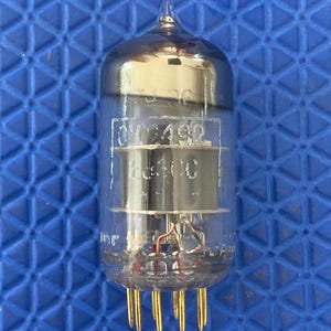 May include: A clear glass valve with a pointed top and gold pins at the base. The valve has internal components and text that reads "01492" and "EC80". The valve is designed for electronic devices.