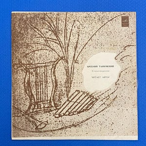 Peut inclure: Une pochette d'album vintage avec une illustration sépia d'une lyre et d'une branche d'arbre. La couverture présente du texte russe, dont le nom "Arseniy Tarkovskiy" et les mots "Lu par l'auteur."