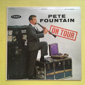 Puede incluir: Portada del álbum "On Tour" de Pete Fountain, con un hombre tocando el clarinete. La portada tiene una estética vintage con el logo de Coral Records y un sello rojo "ON TOUR".