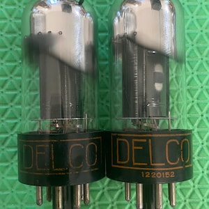 Paire appariée de tubes à vide Sylvania Delco 12V6 12V6GT à plaque noire, dôme chromé et capuchon argenté, neufs d'époque (NOS) testés.