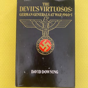 Może przedstawiać: Twarda czarna okładka książki zatytułowanej "The Devil's Virtuosos: German Generals at War 1940-5" autorstwa Davida Downinga. Książka ma złoty tekst i nazistowski emblemat orła. Tło jest żółte.