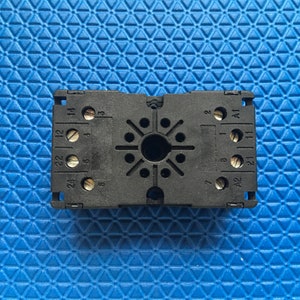 May include: Black plastic electrical component with numbered terminals. The numbers 24, 22, 12, 14, 8, 7, 2, 3, A2, A1, 21, 11, 23 are visible on the component.