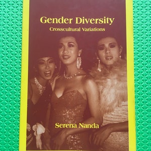 May include: A book titled "Gender Diversity Crosscultural Variations" by Serena Nanda. The cover features a sepia-toned photograph of three people in formal attire. The book has a yellow border and is set against a green background.