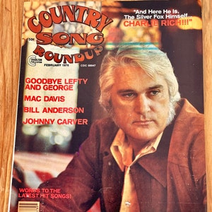 May include: A vintage Country Song Roundup magazine cover featuring a portrait of Charlie Rich, a country music singer. The cover text reads "And Here He Is, The Silver Fox Himself... CHARLIE RICH!!!" and "GOODBYE LEFTY AND GEORGE, MAC DAVIS, BILL ANDERSON, JOHNNY CARVER".