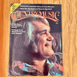 May include: A vintage Country Music magazine cover featuring Charlie Rich, a country music singer, with the title "Country Music" and the text "June 1974, 75 cents".